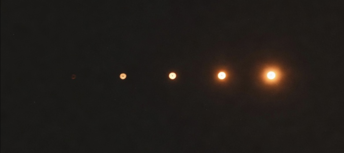 Five dots growing brighter, from nearly invisible to warm amber — proximity to expertise rendered as light.